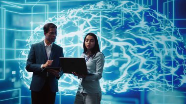 Laptop ve tabletteki görevleri çözen iş arkadaşları, yapay zeka programlama senaryoları çalıştırıyorlar. Yapay zeka uygulamaları geliştirme için kod satırları yazmak için aygıt kullanan IT çalışanları, kamera B