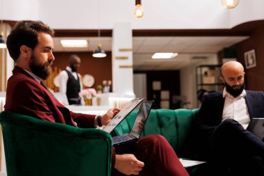 Otel lobisindeki iş temsilcisi önemli uluslararası toplantılara katılmak için iş gezisine çıkıyor. Formalite hazırlama konularında girişimci, dizüstü bilgisayar kullanın.