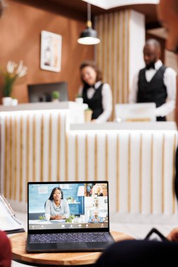 İnsanlar otel resepsiyonunda lobide video görüşmesi yapıp yeni iş geliştirme stratejisini tartışmak için internet üzerinden telekonferansa katılıyorlar. Şirketler arasında gelecekteki ortaklıklar yaratmak.