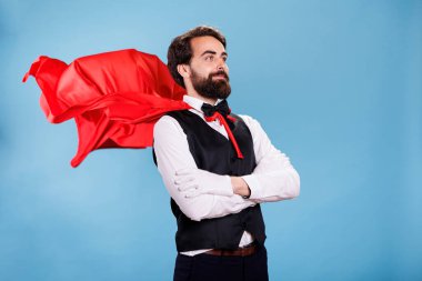 Takım elbiseli ve kamerada kırmızı pelerinli genç adam çizgi filmdeki süper kahraman rolünde. Kırmızı manto giyen güçlü kararlı kişi, insanları kurtarmaya ve kurtarmaya hazır..