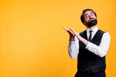 Zarif yetenekli bir adam birini kamerada alkışlıyor stüdyoda alkışlamak için el çırpıyor. Mutlu, pozitif garson, başarının ardından kendine güveni artırmaya çalışıyor..