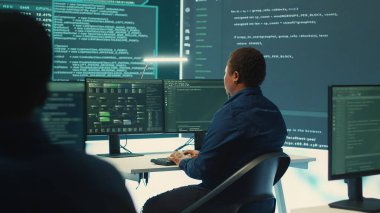 Hükümet hackerları siber tehditlere karşı korunmak için gelişmiş yazılım kullanıyor, ekip halinde çalışıyorlar. Siber güvenlik, veri ve ağ koruma uzmanları yüksek teknoloji ofisinde güçlerini birleştiriyor. Kamera A.