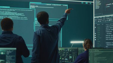 Siber güvenlik ekibi bir hükümet kontrol odasında siber gözetleme yapıyor. Uzman grup hackleme faaliyetleri, kötü amaçlı yazılım koruması ve yüksek teknoloji ajansında veri sızıntısını önleme. Kamera A.