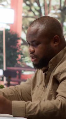 Dikey Video İşletme sahibi, kendi evinde online alışveriş, elektronik bankacılık için kredi kartıyla girişimi için kaynak satın alıyor. Girişimci dizüstü bilgisayardan bir şey satın alıyor. Kamera A.