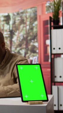 Dikey Video İşletme sahibi, yıllık satış analizleri ve raporları kullanarak tablet üzerindeki bir modelleme ekranının yanında, karı artırmak için mali planları yönetiyor. Girişimci evde bütçe analizi yapıyor