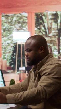 Vertical Video Basarili Serbest Çalışan kredi kartıyla online alışveriş yapar ve merkez ofis kurulumunda elektronik bankacılık işlemleri yapar. İşadamı uzaktan iş yapıyor ve laptoptan bir şeyler alıyor.