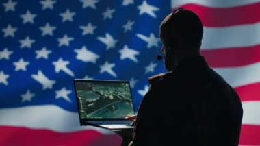 A.B.D. Hava Kuvvetleri harekat subayı cihazdaki izleme iletimini inceliyor, kontrol odasından yer askerlerine kulaklık kullanarak veri aktarıyor, ABD bayraklarında izole edilmiş, kamera A