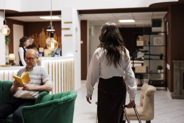 Bavullu yaşlı bayan turist otel lobisine geliyor, kayıt gişesine yaklaşıyor. Kafkasyalı kadın valizleri kavrıyor. Özel dinlenme odasına giriyor. Yaşlı adam rahat koltukta kitap okuyor..