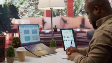 Finans müdürü yeni bir finansman stratejisi için notlar alıyor. Kâr ve harcamaları ev masasında hesaplıyor. İş karını artırmak için çalışmak, muhasebe uzmanı pazar eğilimlerini değerlendirmek. Kamera B.