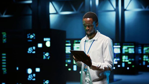 IT programmer in server hub using tablet to find firewall misconfigurations affecting mainframes performance and connectivity, leading to slow data transfer rates and poor client communication