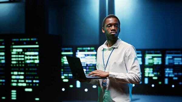 IT developer in server room using laptop to find network issues affecting supercomputer performance and connectivity, leading to slow data transfer rates and poor client communication
