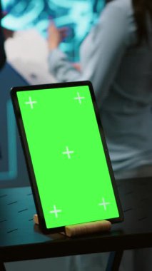 Yapay zeka alanında gelişmeler yapan bilgisayar bilimcileri tarafından kullanılan dikey video yeşil ekran tableti. Yapay zeka sistemlerinin yer aldığı çalışma alanındaki çalışanlar