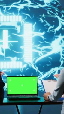 İş veri analizi için izole ekran aygıtı kullanan dikey video Yapay Zeka geliştiricileri. Bilişim departmanı personeli, yapay zeka ve kamera kullanarak görevleri otomatik hale getirmek için kroma anahtar defteri üzerinde çalışırlar.