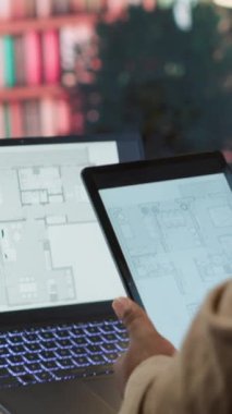 Dikey Video Girişimcisi mimari planları değerlendiren, iç tasarımcılara ilham verici bir çalışma alanı yaratmak için danışan bir ofis yerleştirme planı planlıyor. Mülk kiralama için avcılık. Kamera.