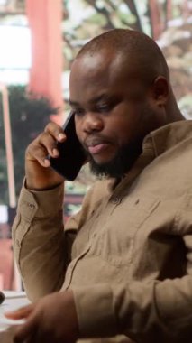 Yatırımcılarla telefonda görüşen Dikey Video İş Yöneticisi, analiz sırasında satış rakamlarını ve performans ölçümlerini iletiyor. Girişimci yeni fonlar elde etmeyi umuyor