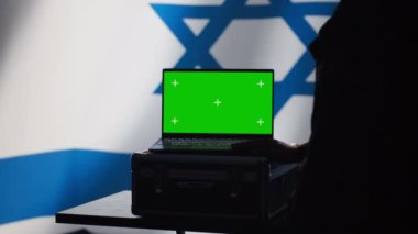 İsrail Hava Savunma Komutanlığı operatörü, yaklaşan füzeleri tespit etmek için radarla yeşil ekran dizüstü bilgisayar kullanıyor. IDF askeri roketleri tarıyor ve kalkanları model defter ve kamera A ile açıyorum.