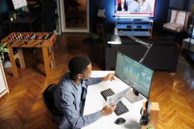 Mali analist yasal belgeleri ve çevrimiçi bakiyeyi kontrol ederek maliyet ve gelir unsurlarını hesaplıyor, evde muhasebe işlerini yapıyor. Ekonomist bütçe incelemesi için sermaye fonu analizini inceliyor.