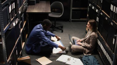 Afro-Amerikan polisi ofis zeminindeki suç dosyalarını okuyor. Detayları ve ipuçlarını bulmaya çalışıyor. Çok ırklı dedektifler dava bilgilerini inceler, adli kanıt ararlar..