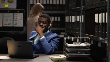 Odaklanmış Afro-Amerikan dedektifi kanıtları inceler ve Kafkas müfettişi araştırma yaparken ipuçlarını analiz eder. Siyahi polis karmaşık davaları çözmek ve adaleti sağlamak için dizüstü bilgisayarla oturuyor.