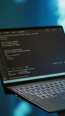 Dikey video mühendisi, yapay zeka sinir ağlarını korumak için dizüstü bilgisayar kullanıyor. Bilgi işleme ve iletimine yardımcı olan yapay zeka sistemini kullanan bilişim uzmanının yakın plan görüntüsü, kamera A