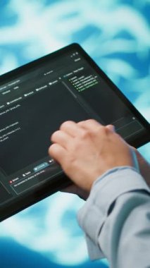 Yapay zeka sinir ağlarını korumak için tablet kullanan dikey video programcısı. Bilgisayar bilimcisinin yapay zeka sistemini kullanarak bilgi işlemeye ve iletmeye yardım ederken yakın plan görüntüsü