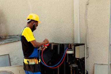 Klima buharlaştırıcı bobinlerindeki don şikayeti üzerine müşteri tarafından işe alınan uzman tamirci. Hvac sistem optitimum düzeltme yöntemini saptamak için manifold göstergeleri kullanan uzman tamirci