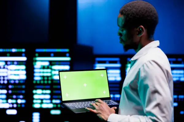 stock image Engineer using green screen laptop to do hardware maintenance in professional data center. Expert optimizing server room equipment, ensuring seamless data operations and system stability