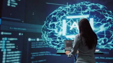 Bilgisayar bilimci AI alanında gelişmeler yapıyor. Yapay zeka ve sinirsel ağ sistemlerinin yer aldığı ileri teknoloji iş yerinde dizüstü bilgisayarda çalışan kadın, kamera B