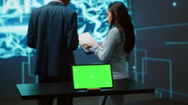 Yapay zeka programcıları iş veri analizi için yeşil ekran dizüstü bilgisayar kullanıyorlar. Yüksek teknoloji konum uzmanları, yapay zeka ve kamera A kullanarak görevleri otomatikleştirmek için kroma anahtar defteri üzerinde çalışırlar.
