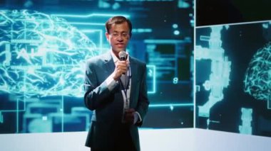 Sunucu, yapay zeka ve bilişsel bilgisayar alanındaki son gelişmelerle ilgili görüşleri paylaşan bilişim uzmanlarını bir araya getiren yapay zeka kongresindeki izleyicilerle konuşuyor. Kamera A