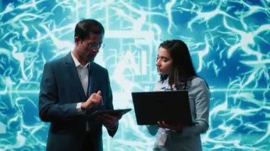 Laptop ve tabletteki görevleri çözen iş arkadaşları, yapay zeka programlama senaryoları çalıştırıyorlar. IT personeli, AI uygulamaları geliştirme ve kamera A için kod satırları yazmak için aygıtlar kullanıyor.