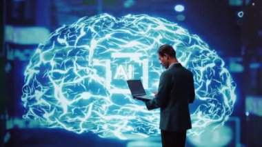 Bilgisayar üzerinde çalışan bir sistem yöneticisi, yapay zeka programlıyor insan beyni simülasyonu yapıyor. Çalışma alanındaki adam not defteri kullanıyor, yapay zeka makinesi inşa ediyor algoritmaları öğreniyor, kamera B