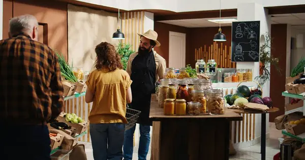 stock image Owner greeting first customers at sustainable zero waste supermarket grand opening ceremony, removing red ribbon. Entrepreneur welcoming shoppers inside eco friendly local grocery store