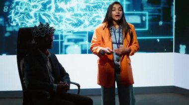 Yapay zeka ve kamera A 'yı beyin ile bağlamak için EEG kulaklığının nasıl kullanılacağını gösteren, teknolojik girişimleri ve akademisyenleri bir araya getiren AI konferansında gösteri yapan nörobilimci.