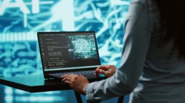 AI bilgisayar bilimcisi yüksek teknoloji çalışma alanında iş veri analizi için dizüstü bilgisayar kullanıyor. Hintli kadının yapay zeka ve kamera A 'yı kullanarak görevleri otomatikleştirmek için defter üzerinde çalışırken yakın plan görüntüsü.