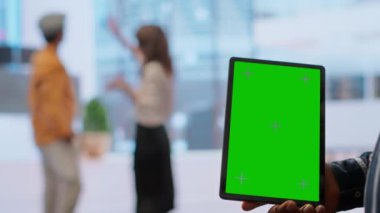 Emlakçılar ve müvekkil, yeni modern ofis geliştirme planı üzerinde birlikte çalışarak yeşil ekranın yanındaki planları inceliyorlar. Çalışma alanı tasarım vizyonu paylaşılıyor. Kamera B.