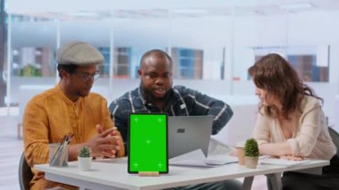 İnsanlar krom ekranın yanındaki satıcıyla tartışıyor, yeni ofis alanının planlarını değerlendirmek için buluşuyorlar. Finansörle gayrimenkule yatırım yapan iş ortakları. Kamera B.