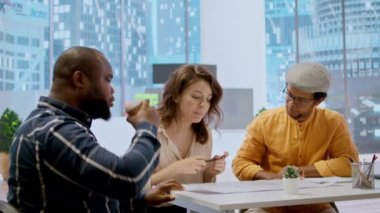 Bir ofis turunda bir gayrimenkul komisyoncusuyla görüşen girişimci müşteriye üst sınıf çalışma alanı etrafında rehberlik ediyor ve mimari planlar ve planlar sunuyor. İş yatırımı. Kamera A.
