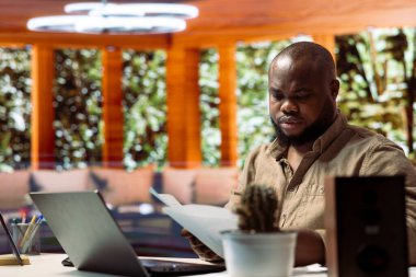 Bilgisayarında mali denetimler ve bütçe planlaması üzerinde çalışan serbest çalışan analist, evdeki kişisel ticaret işleri için çevrimiçi pazarlama ve geliştirme stratejileri yürütüyor..