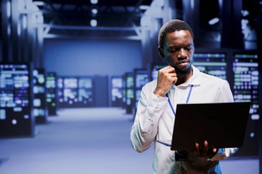 Bıçak sunucularını inceleyen elektrikçi müşterilere internet içeriği dağıtıyor. Afrika kökenli Amerikalı telsizci kritik sistemleri not etmek için dizüstü bilgisayar kullanıyor. Zarar verici hatalar arıyor.