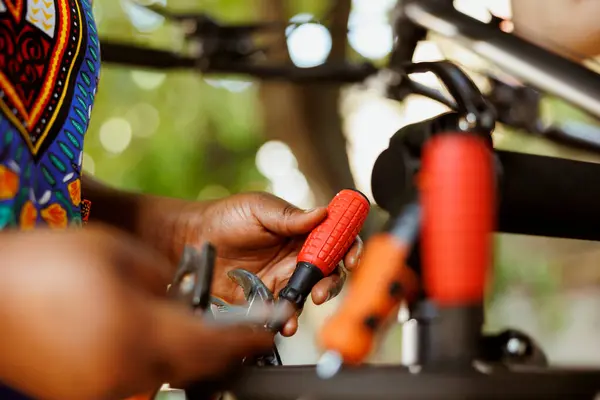 stock image Close-up shot of african american hands grasping bicycle tools from professional toolbox for maintenance and repairs. Detailed image of individual adjusting specialized equipments.