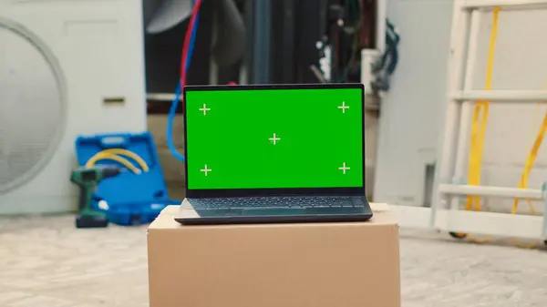 stock image Green screen laptop in front of malfunctioning outdoor condenser. Mock up chroma key gadget display next to defective outside HVAC system in need of professional maintenance