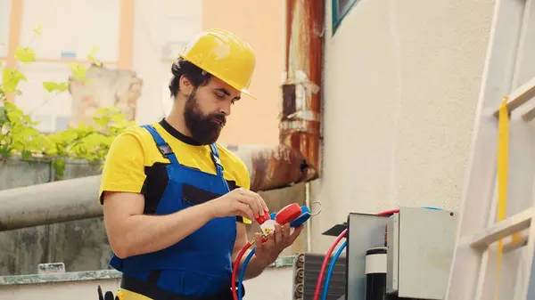 stock image Precise repairman contracted by client to detect air conditioner issues, tracking nitrogen pressure loss and adjusting superheat and subcooling level values measured by ac gauges vacuum pump