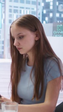 Genç yetişkinlerin kişisel finansal planlarını okuduğu dikey video. Mali müşavirin ofisinde yaptığı toplantı sırasında. Ekonomik kararların nasıl kârlı ve geleceğe dönük olacağını okuyan gençler, kamera A