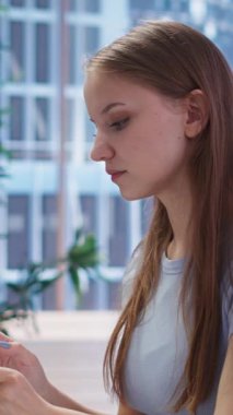 Dikey video Gen Z genç yetişkin toplantı sırasında mali danışman tarafından yazılan kişiselleştirilmiş planlama rehberine bakıyor. B kamerasından yardım isteyen gençlerin yaşam masraflarını optimize eden danışman.