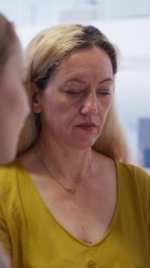 Vertical video finans danışmanı müşterilerle konuşuyor, optimal finansal hizmetler ve yatırımlar öneriyor. Ajan, anne ve genç yetişkine en iyi yatırım stratejileri B kamerasını bildiriyor.