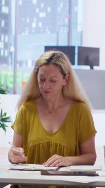 Dikey video finans danışmanı müşterileri anlaşma evraklarını imzalamaya davet ediyor. Bu da onu yatırımlarını yönetmekten sorumlu yapıyor. Müşteriler sözleşme imzalıyor, ortaklığa giriyorlar.