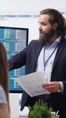 Şirket finans departmanındaki dikey video takımı lideri yatırım varlıklarının toplandığı büyük ekranda hisse senedi portföyünü gösteriyor. İşadamı hisse senedi talebinde büyük artış gösteriyor