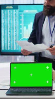 İzole ekran dizüstü bilgisayarda sunum yapan dikey video finans danışmanı, müşterilerin kaydetme alışkanlıkları oluşturmasına yardımcı oluyor, kapatın. Menajer müşterileri ipuçları verirken göstermek için kroma anahtar defteri kullanır, kamera B