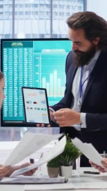 Dikey video finans danışmanı, geniş ekran ve tablet aygıtı kullanarak müşterilere pazar analizlerini sunarak nasıl portföy oluşturulacağını öğretiyor. Borsa çizelgelerini ebeveyne ve kıza gösteren broker